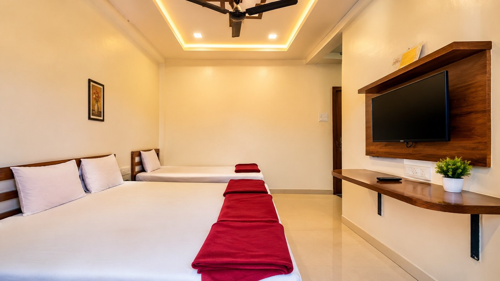 Room with twin beds and wall-mounted TV